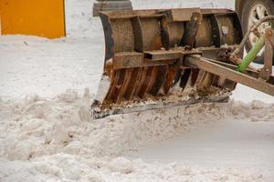 Snow removal from the streets with the help of special equipment in winter photo