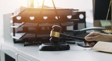 Male lawyer working with contract papers and wooden gavel on tabel in courtroom. justice and law ,attorney, court judge, concept. photo