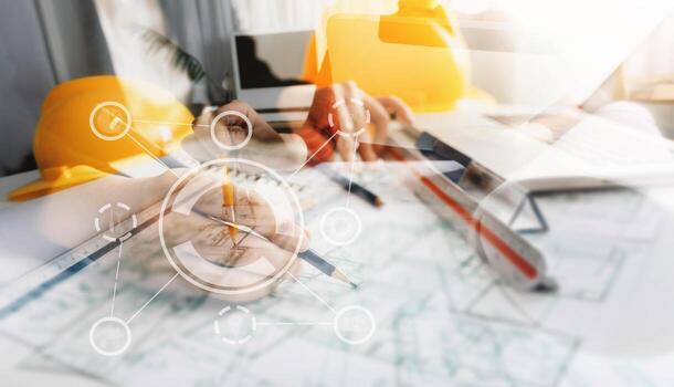 Two colleagues discussing data working and tablet, laptop with on on architectural project at construction site at desk in office photo