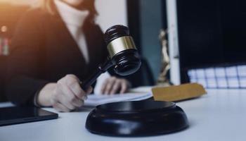 Male lawyer working with contract papers and wooden gavel on tabel in courtroom. justice and law ,attorney, court judge, concept. photo