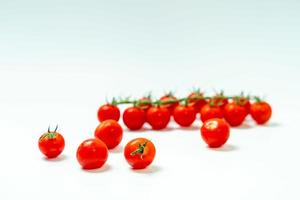 tometoes aislar sobre fondo blanco. manojo de tometos rojos aislados en fondo blanco, es fresco, nutritivo y cítrico foto