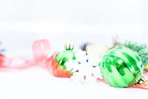 navidad de invierno - bolas de navidad con cinta en la nieve, concepto de vacaciones de invierno. bolas verdes de navidad, bolas doradas, decoraciones de pino y copos de nieve en el fondo de la nieve foto