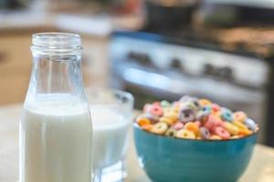 Tazón de coloridos cereales y leche para niños aislado en una mesa de madera con espacio de texto foto