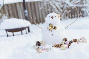 feliz navidad y feliz año nuevo tarjeta de felicitación con espacio de copia. muchos muñecos de nieve de pie en el paisaje navideño de invierno. fondo de invierno. muñeco de nieve con flor seca y pino. felices fiestas y celebraciones. foto