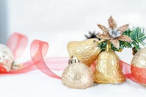 navidad de invierno - bolas de navidad con cinta en la nieve, concepto de vacaciones de invierno. bolas rojas de navidad, bolas doradas, decoraciones de pino y copos de nieve en el fondo de la nieve foto