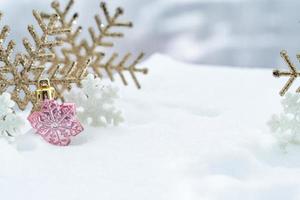 navidad de invierno - bolas de navidad con cinta en la nieve, concepto de vacaciones de invierno. bolas rojas de navidad, bolas doradas, decoraciones de pino y copos de nieve en el fondo de la nieve foto