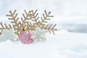 Christmas of  winter - Christmas balls with ribbon on snow, Winter holidays concept. Christmas red balls, golden balls, pine And Snowflakes decorations In Snow Background photo