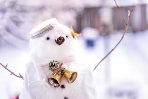 feliz navidad y feliz año nuevo tarjeta de felicitación con espacio de copia. muchos muñecos de nieve de pie en el paisaje navideño de invierno. fondo de invierno. muñeco de nieve con flor seca y pino. felices fiestas y celebraciones. foto