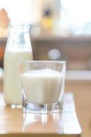 reptientes con leche sobre una mesa de madera y fondo rústico de cocina. concepto de leche alternativa. vista frontal. composicion horizontal foto