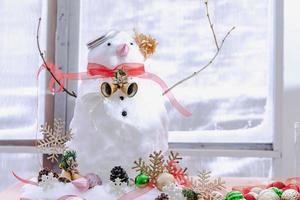 Merry Christmas and happy New Year greeting card with copy-space.Many snowmen standing in winter Christmas landscape.Winter background.Snowman with Dry Flower and pine . Happy holiday and celebration. photo