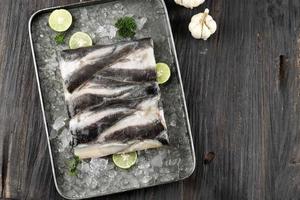 Raw Catfish FIllet with Skin, Top View on Wooden Background. photo