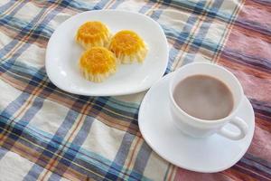 Cup of hot cocoa with gold egg yolk thread cakes on vintage tablecloth for the new morning. photo