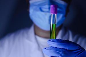 A scientist or researcher in a laboratory holds a test tube to invent a vaccine against the coronavirus. Concept of treatment Medical experiments prevent the spread of the covid-19. photo