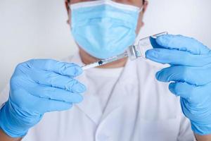 Doctors or scientists hold syringes and vials with the COVID-19 vaccine to try injections to treat patients in hospitals. Medical experiments prevent the spread of the coronavirus photo