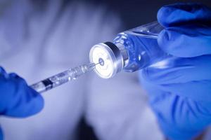 Doctors or scientists hold syringes and vials with the COVID-19 vaccine to try injections to treat patients in hospitals. Medical experiments prevent the spread of the coronavirus photo