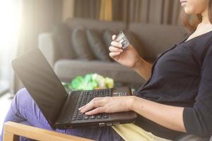 Close Up Of A woman Shopping Online Using Laptop With Credit Card photo