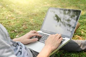 young man with laptop outdoors photo