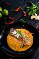 Pork red curry served and decorated with vegetables, herbs and spices on rustic background - Thai food