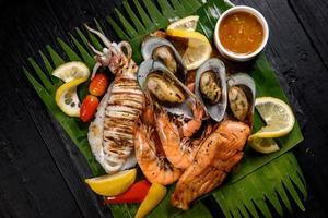 Mixed seafood grill including blue crab, mussels, large shrimp, squid and grilled salmon photo