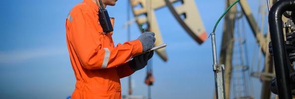 man working in Oil field site, climb oil tank for working photo