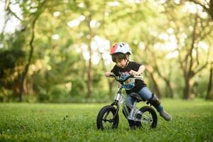 Bangkok Thailand - Oct 09, 2016  happy cheerful child boy riding a bike in Park in the nature photo