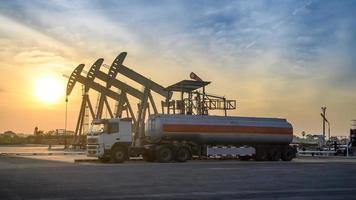 sitio del campo petrolero, por la noche, bombas de aceite y camión de aceite foto