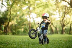 Bangkok Thailand - Oct 09, 2016  happy cheerful child boy riding a bike in Park in the nature photo