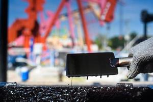 hombre que trabaja en el sitio del campo petrolero, sube al tanque de aceite para trabajar foto