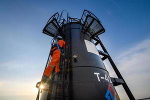 man working in Oil field site, climb oil tank for working photo
