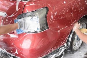 hand hold sponge over the car for washing photo