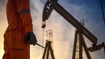 silueta de trabajadores petroleros trabajando por la noche y hermosa puesta de sol. foto