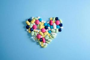 Surtido de píldoras, tabletas y cápsulas de medicamentos farmacéuticos para el tratamiento de enfermedades del corazón. forma de corazón de pastillas. copiar espacio para texto foto