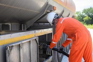 un hombre trabaja en un campo petrolero y está usando tuberías de aceite para repostar. foto