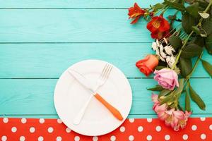 Festive dinner and roses on blue wooden background. Top view. Mock up. Flowers. Copy space photo