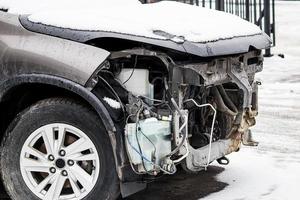 Broken car after accident on road. Auto without bumper and headlights. Insurance concept. photo