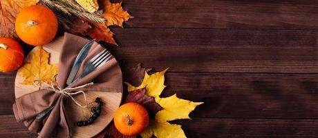 Thanksgiving cutlery setting. Festive table decor on wooden background. photo