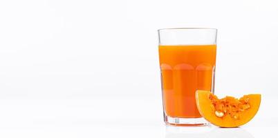 Pumpkin juice in transparent glass isolated on white background. Vegetable vegetarian drink. Healthy food and diet. photo