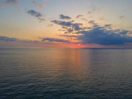 Calm sea with sunset sky and sun over clouds. Meditation ocean and sky background. Calm sea view. Horizon over the water. photo