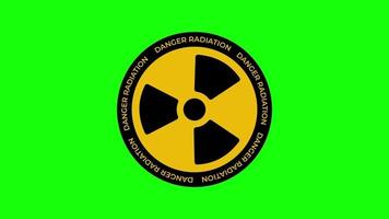 radiación animada dando vueltas. símbolo de signo nuclear gira alrededor aislado sobre fondo verde. el signo radiactivo amarillo gira sobre un fondo verde. gráficos en movimiento video