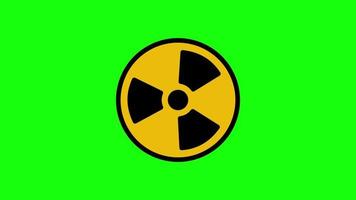 rayonnement animé tournant autour. le symbole du signe nucléaire tourne autour isolé sur fond vert. le signe radioactif jaune tourne sur un fond vert. graphiques animés video