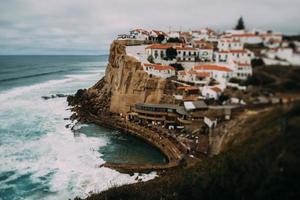 vista a azenhas do mar playa rocosa y pueblo en colares, portugal. efecto de cambio de inclinación foto