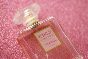 ternopil, ucrania - 2 de septiembre de 2022 coco mademoiselle chanel paris mundialmente famoso frasco de perfume francés sobre fondo brillante en colores púrpura foto