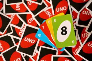 TERNOPIL, UKRAINE - MAY 15, 2022 Many colorful UNO game cards. UNO is an American shedding-type card game that is played with a specially printed deck photo