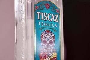 KHARKIV, UKRAINE - NOVEMBER 3, 2021 Tiscaz tequila alcohol bottle with traditional mexican pattern and art design on glass surface. photo