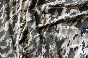 Fabric with texture of Ukrainian military pixeled camouflage. Cloth with camo pattern in grey, brown and green pixel shapes. Official uniform of Ukrainian soldiers photo