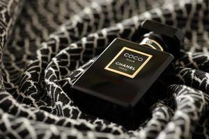 ternopil, ucrania - 2 de septiembre de 2022 coco noir chanel paris mundialmente famoso frasco de perfume francés en la vieja tela escocesa con patrón monocromo foto