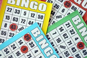 Many colorful bingo boards or playing cards for winning chips. Classic US or canadian five to five bingo cards on bright background photo