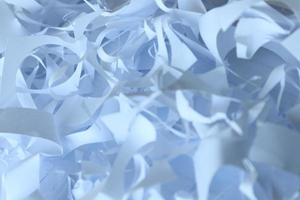 Shredded paper texture background, top view of many white paper strips. Pile of cut paper like box filler for shipping fragile items photo