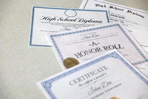 sobre la mesa hay un reconocimiento del cuadro de honor, un certificado de logros y un diploma de escuela secundaria. documentos educativos
