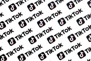 ternopil, ucrania - 2 de mayo de 2022 muchos logotipos de tiktok impresos en papel. tiktok o douyin es un famoso servicio chino de alojamiento de videos de formato corto propiedad de bytedance foto